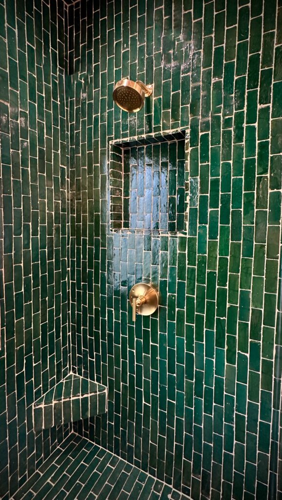 green bathroom tile copper fixtures